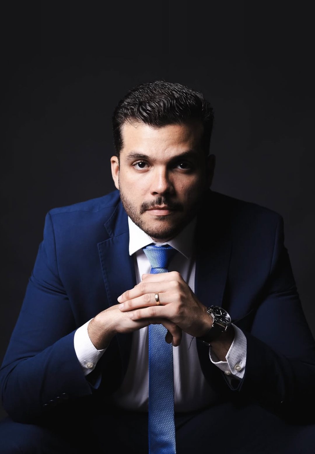 Lucas Frade, advogado, em retrato de estúdio com terno azul-marinho.
